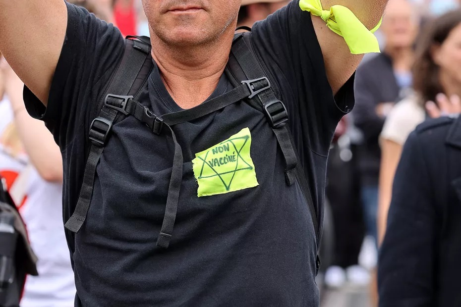 Egy férfi sárga csillagot visel, amelyre "nincs beoltva" felirattal tüntetnek az egészségügyi bérlet meghosszabbítása ellen Párizsban Kép / Forrás / france3-regions.francetvinfo.fr